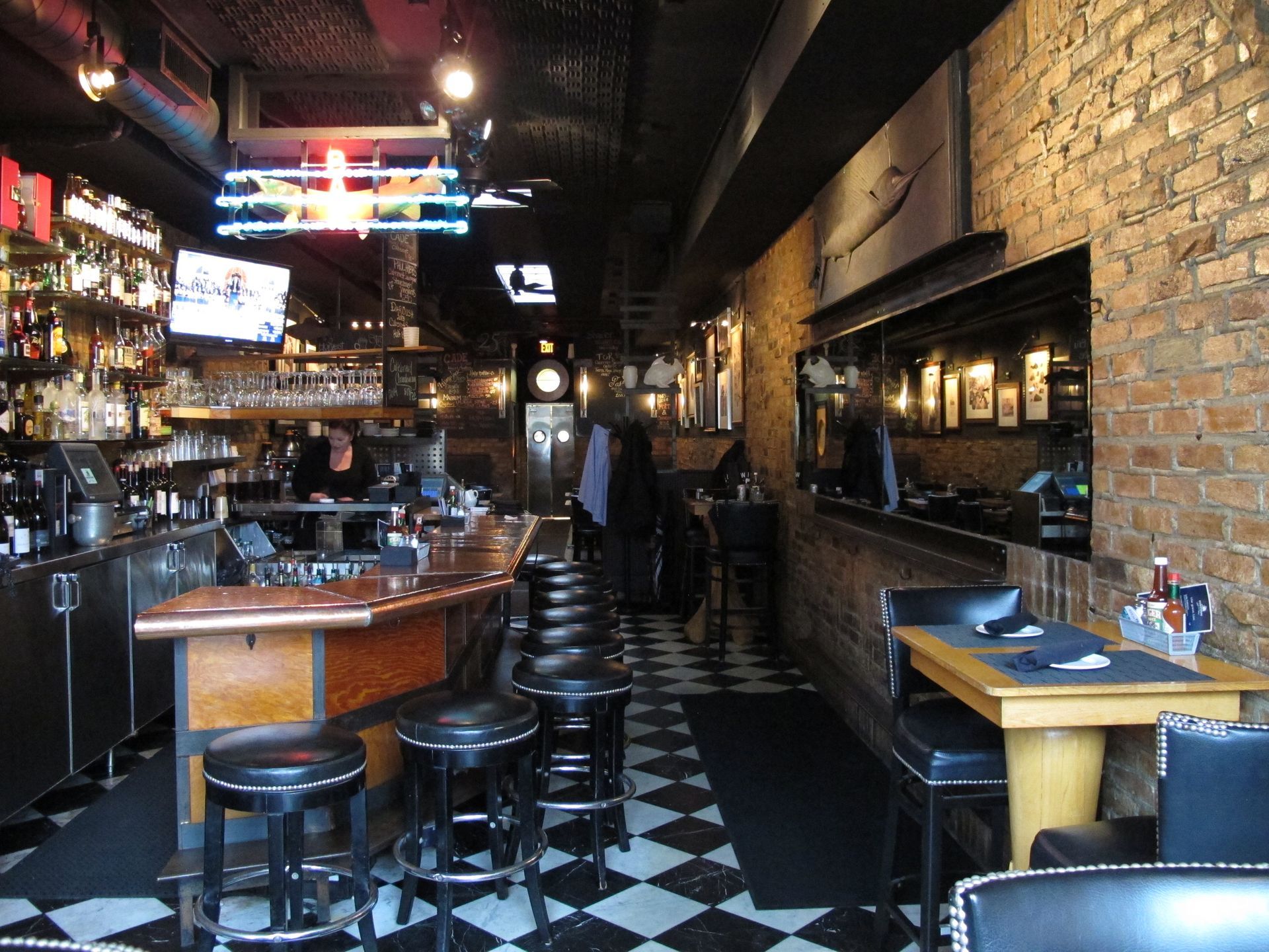 A restaurant with a checkered floor and tables and chairs
