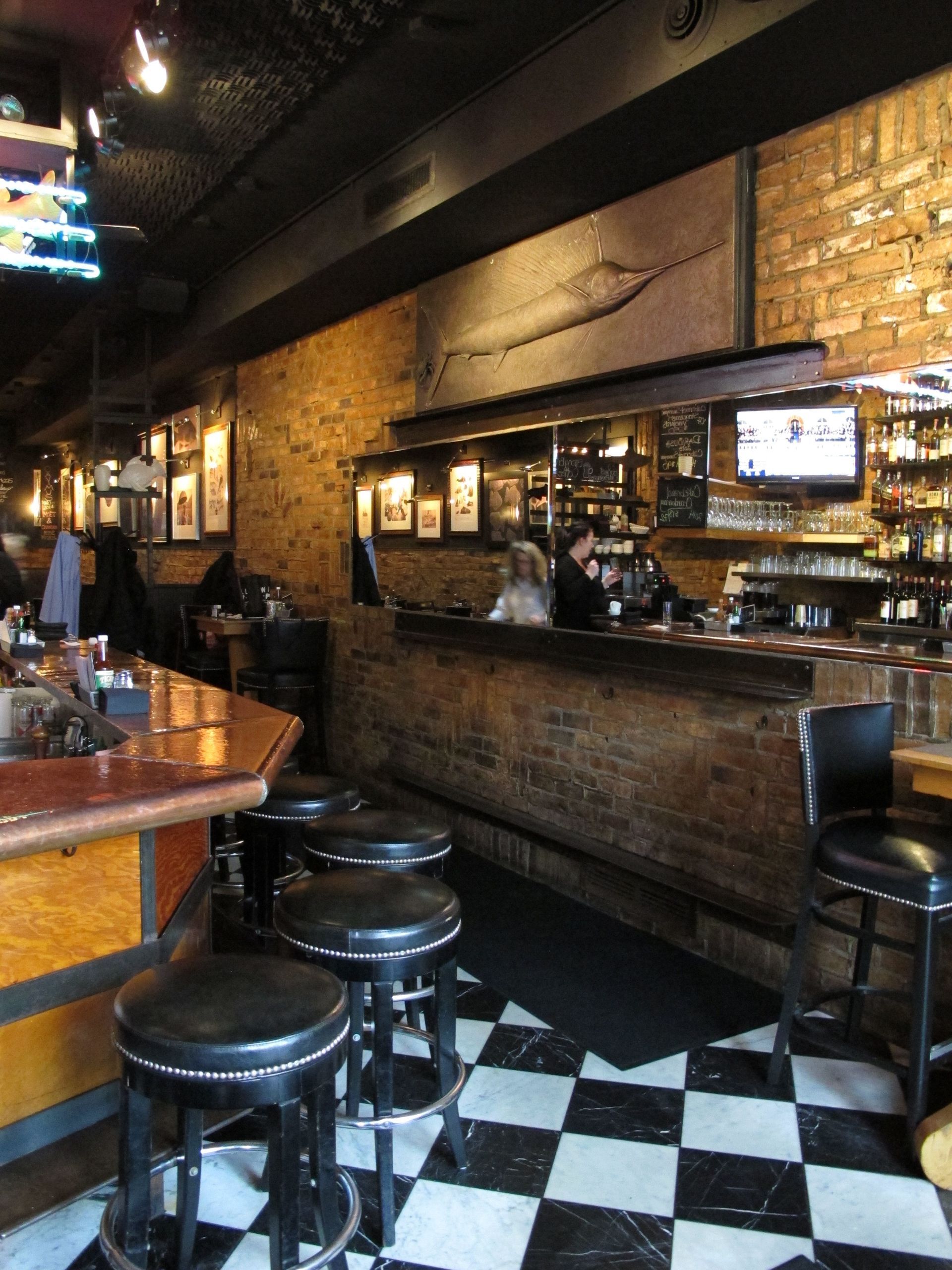 A restaurant with a checkered floor and stools