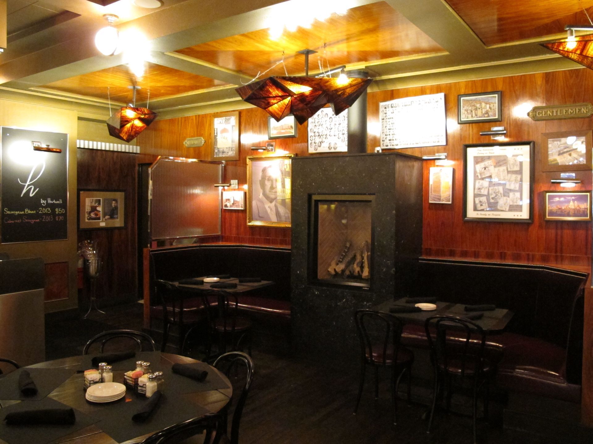 A restaurant with tables and chairs and a fireplace