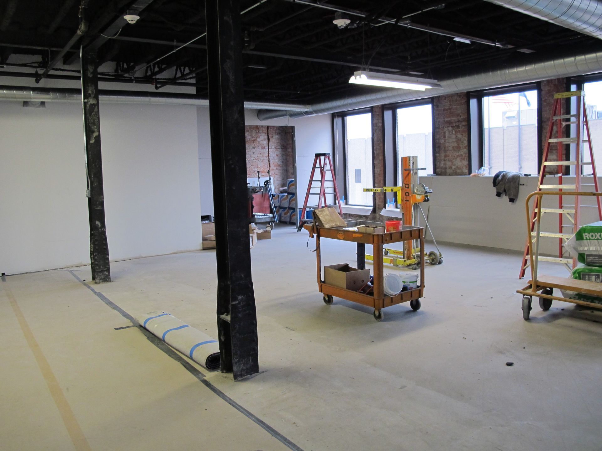 An empty room with a cart and a ladder in it