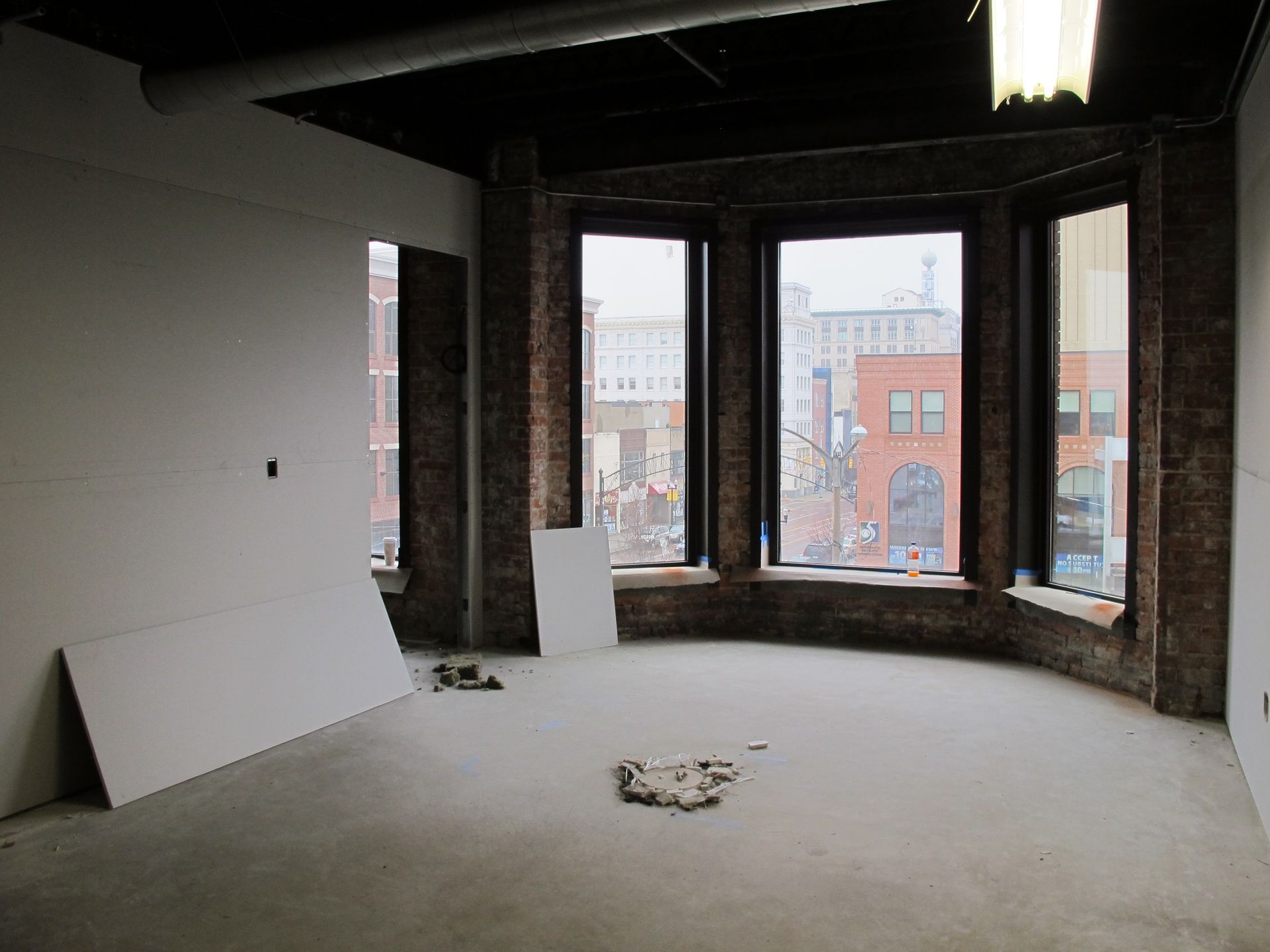 An empty room with a lot of windows and a brick wall
