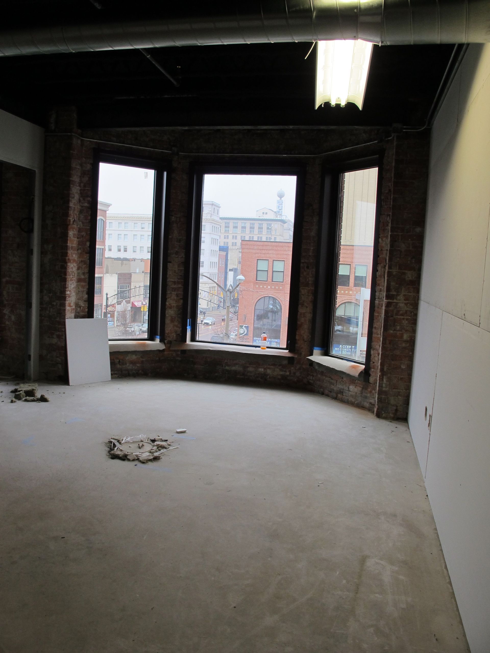An empty room with a lot of windows and brick walls