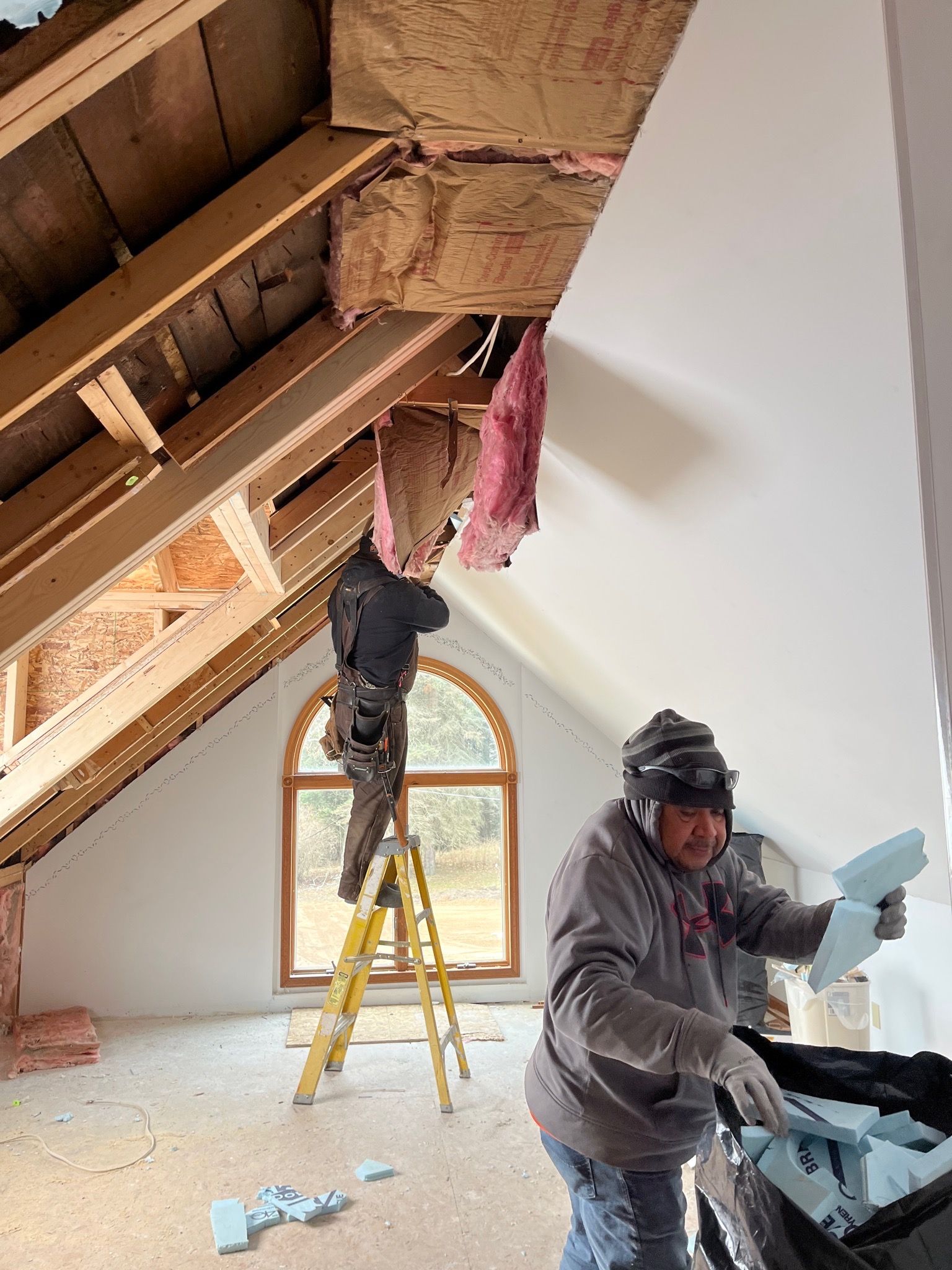 Two workers insulating an attic