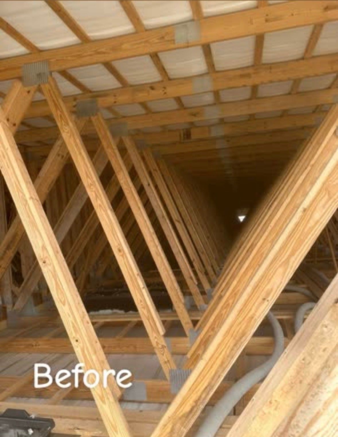 Dark attic interior with wooden beams and insulation