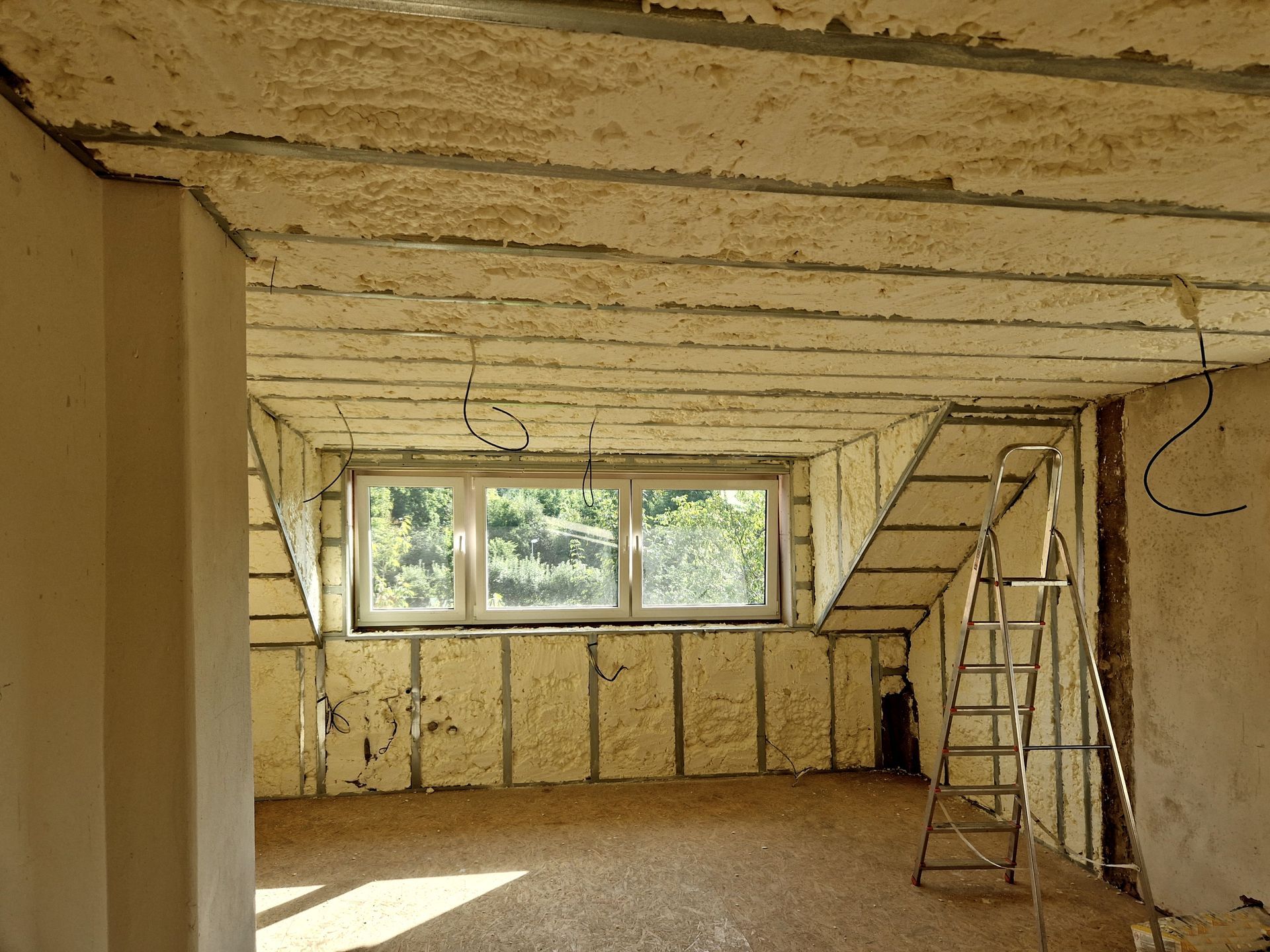 Interior room under construction, walls and ceiling insulated with foam.
