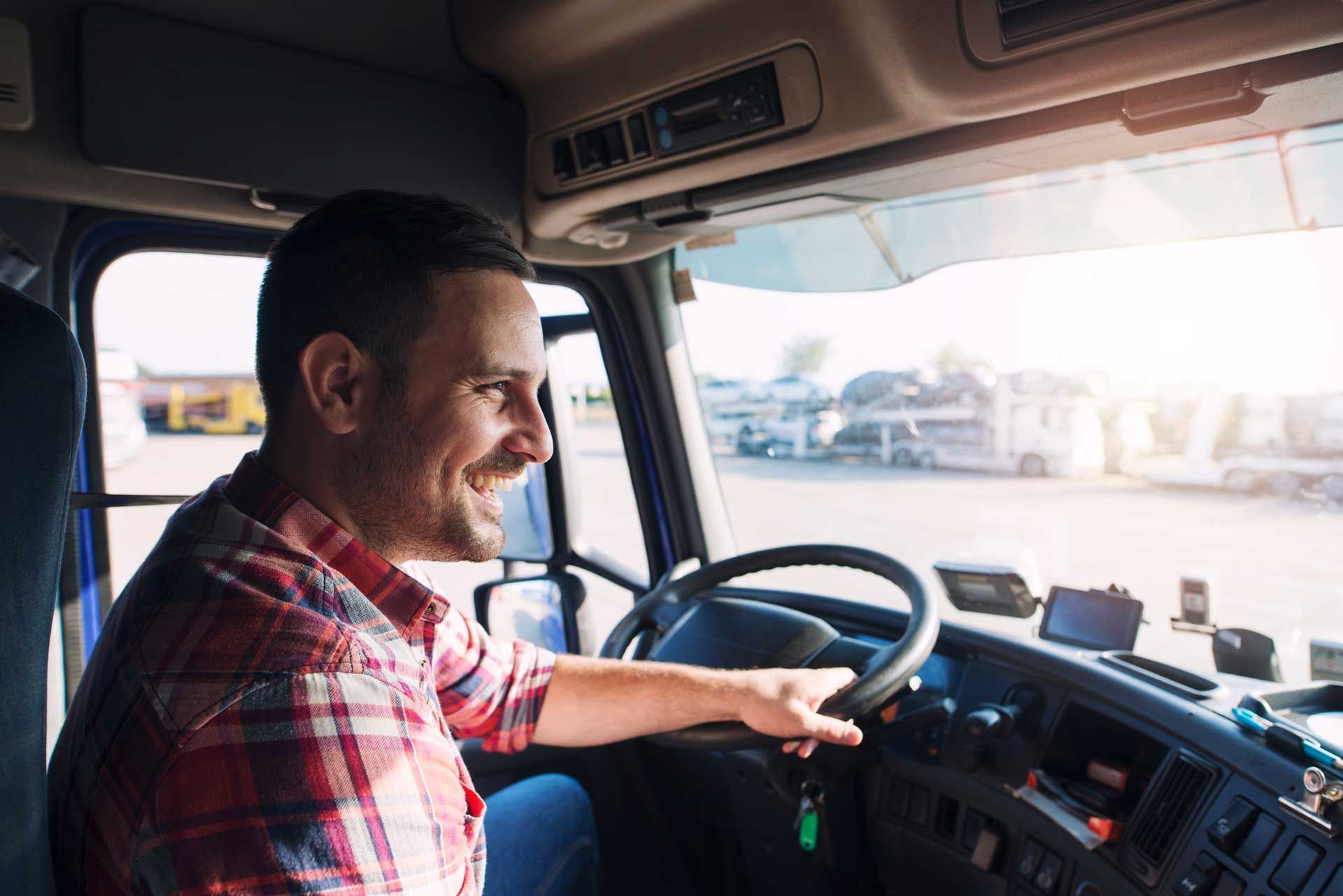 A man is sitting in the driver 's seat of a semi truck.