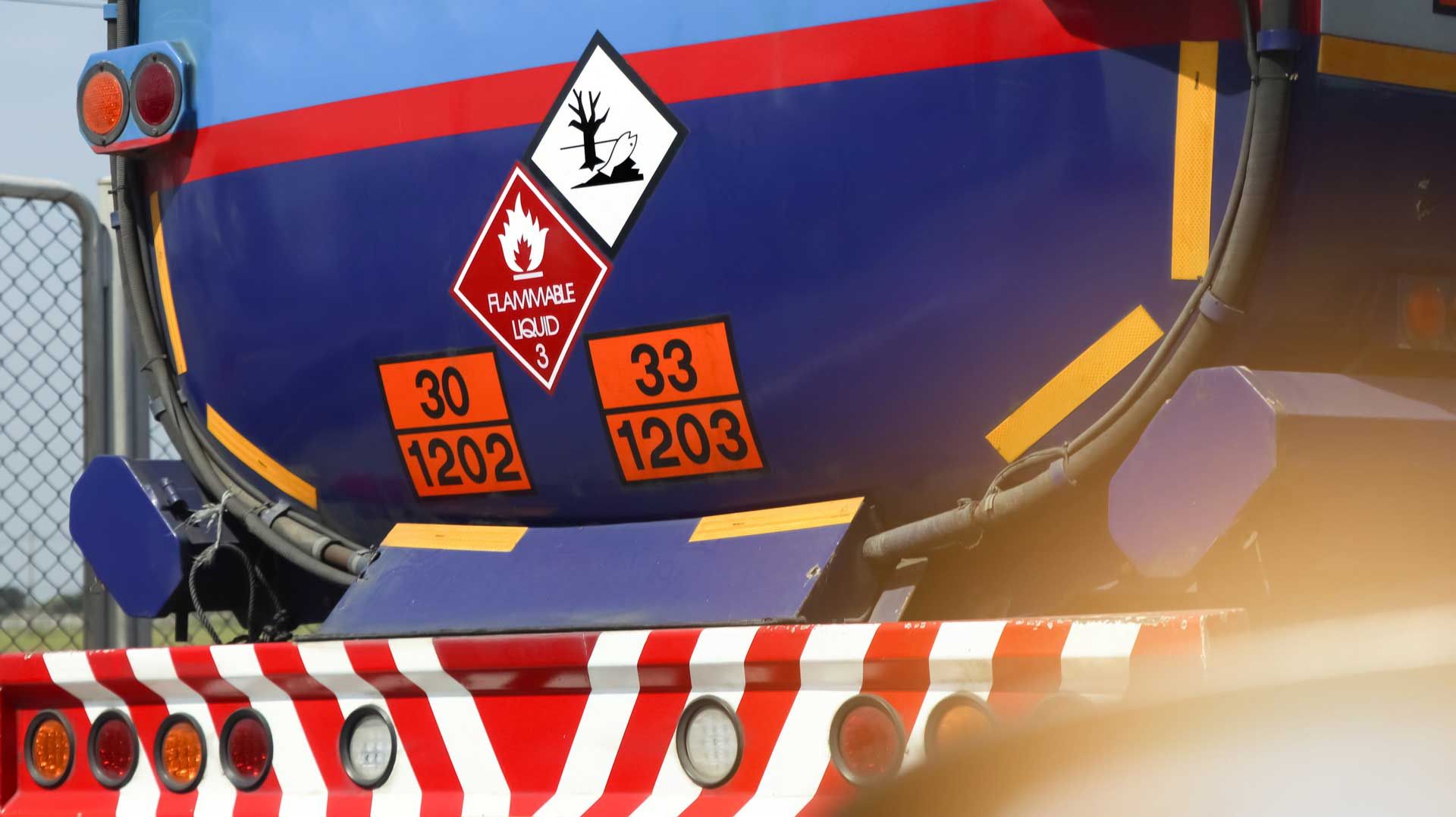 A blue and red truck with a warning sign on the back