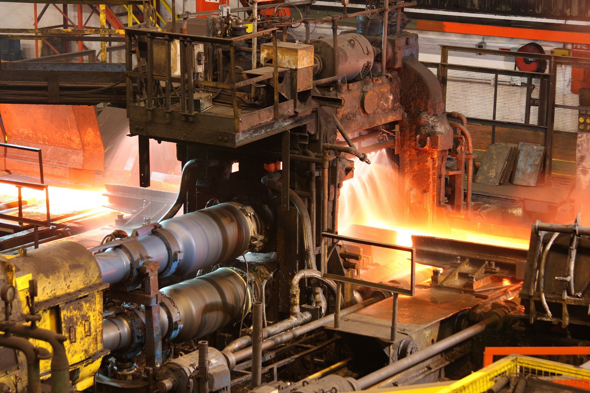 Molten metal flowing through heavy industrial machinery inside a manufacturing or foundry facility.