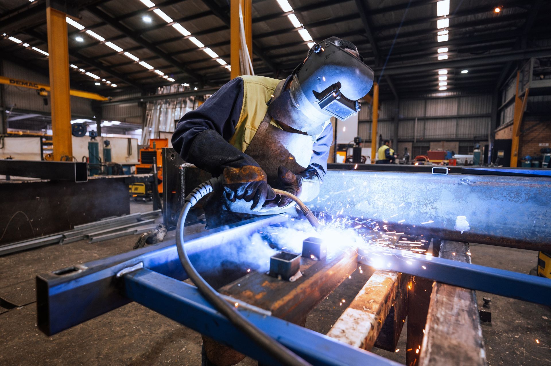 Image of a welder in protective gear working on metal.