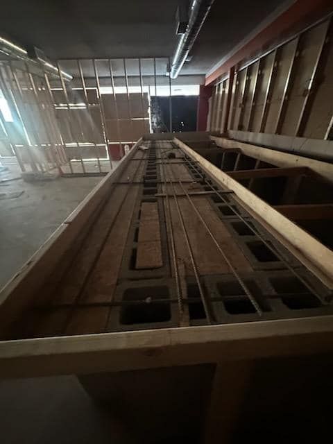 Construction site: wooden framework, exposed metal rebar, and unfinished walls.