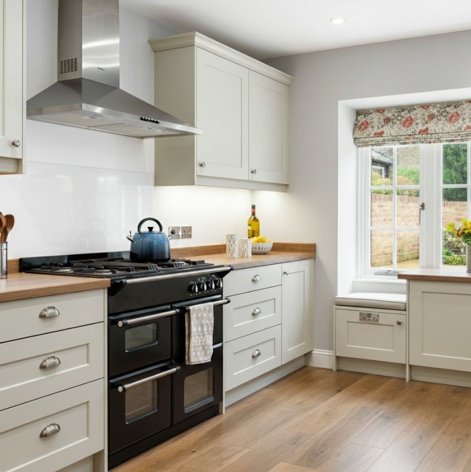 A kitchen with white cabinets and a black stove top oven