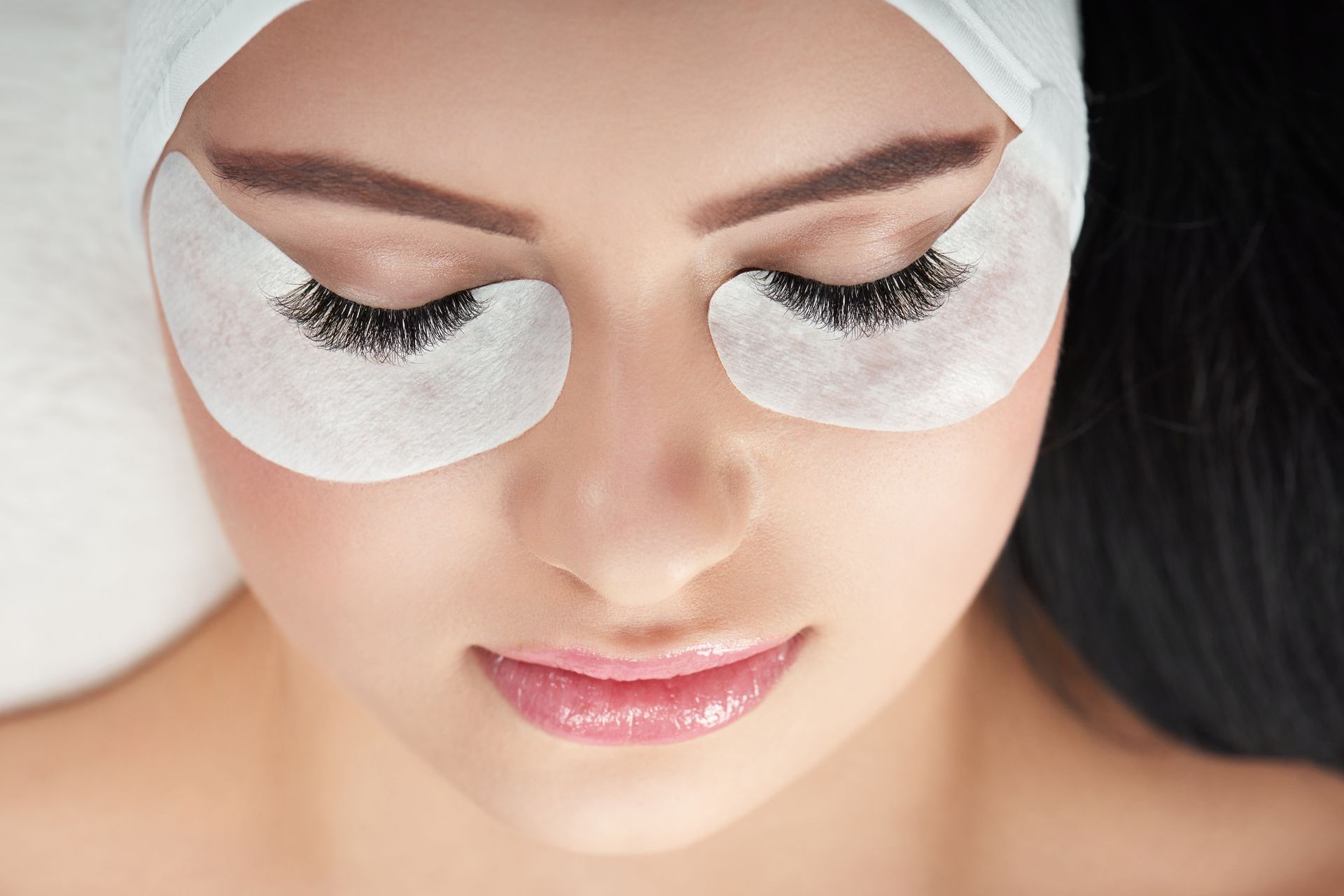 A close up of a woman 's face with eye patches on her eyes.