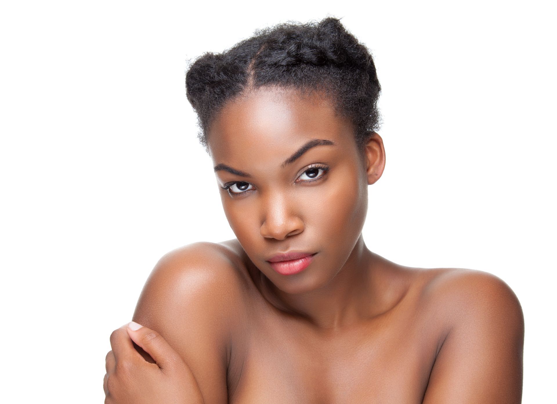 A woman without a shirt is looking at the camera with her hands on her shoulder.