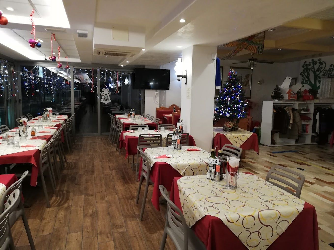 un ristorante pieno di tavoli e sedie decorati per natale .