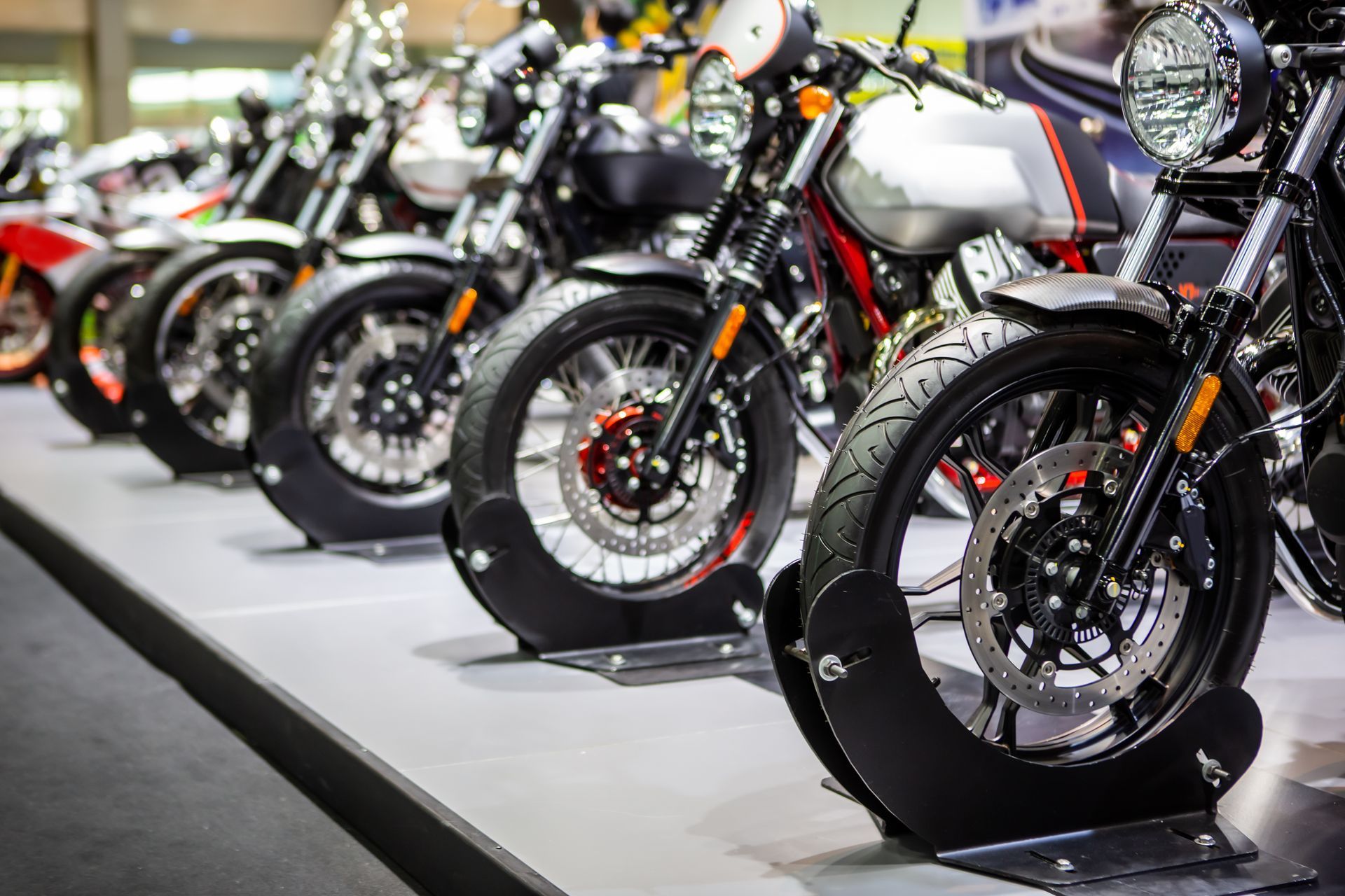 A row of motorcycles are lined up on display at a motorcycle show.