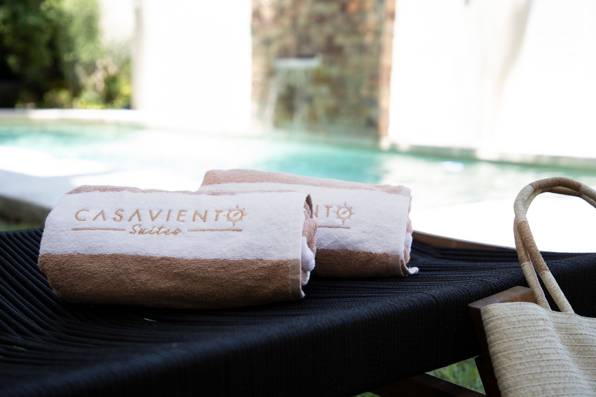 Dos toallas están sentadas en una silla al lado de una piscina.