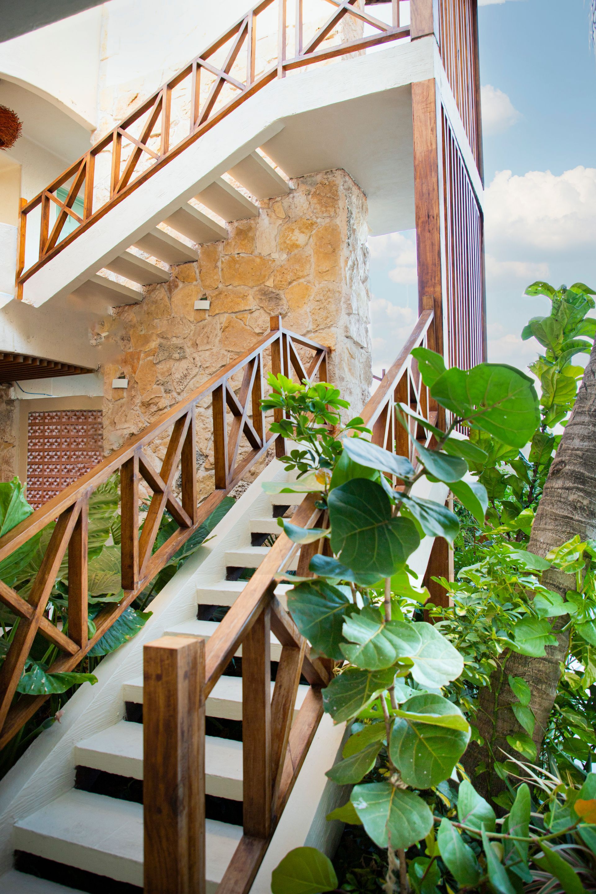 Un conjunto de escaleras que conducen a un edificio con barandilla de madera.