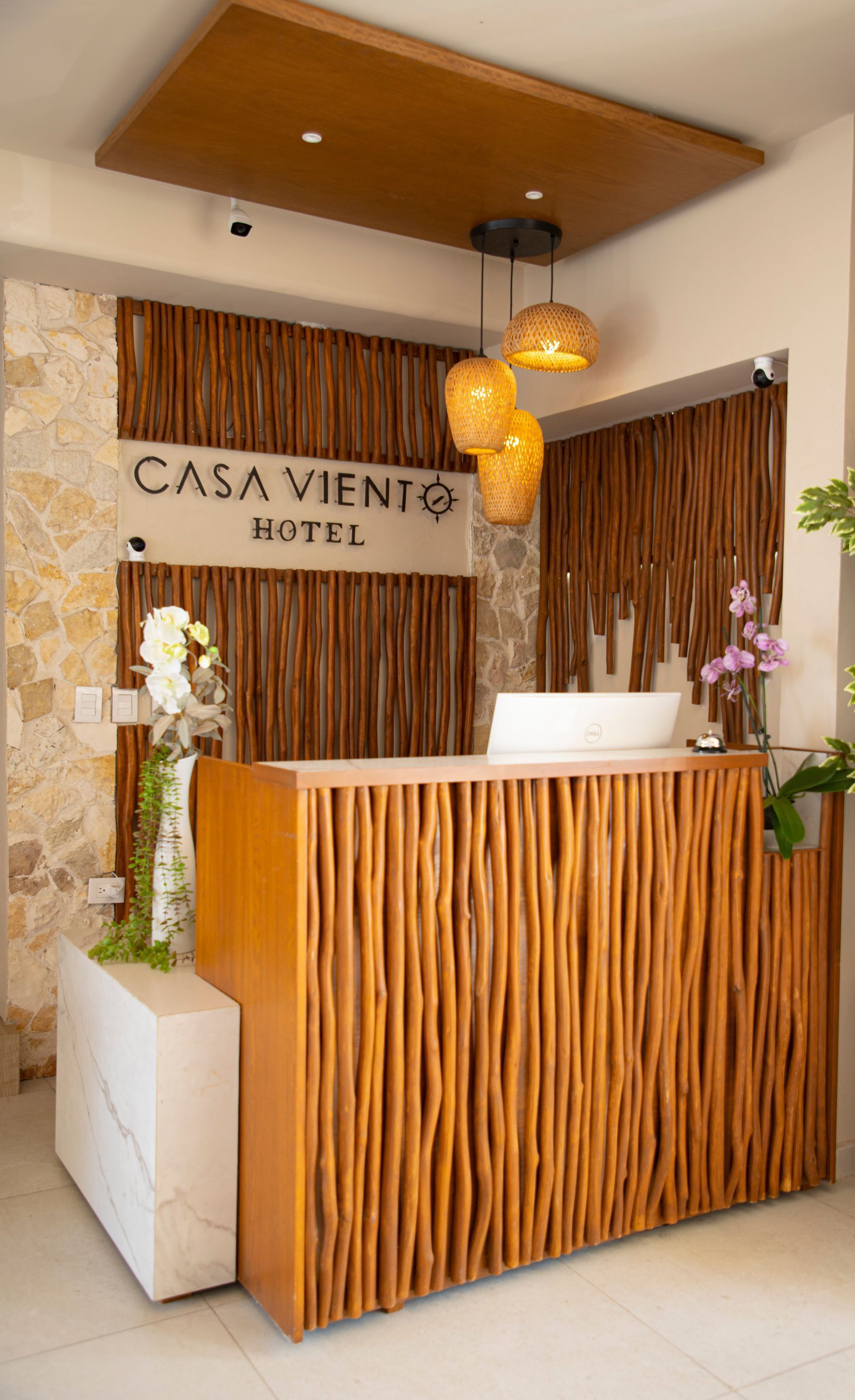 Un vestíbulo de hotel con un mostrador de madera y un cartel que dice Casa Viento Hotel.