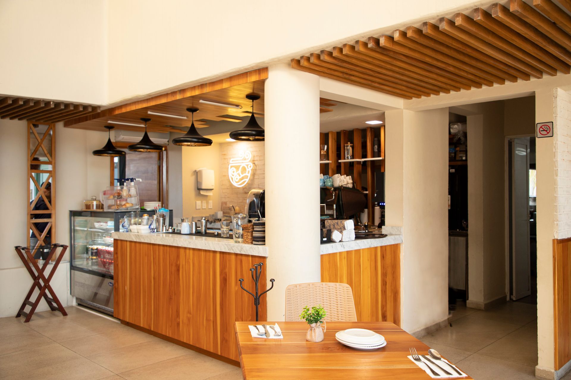 Un restaurante con mostrador de madera y mesas y sillas.