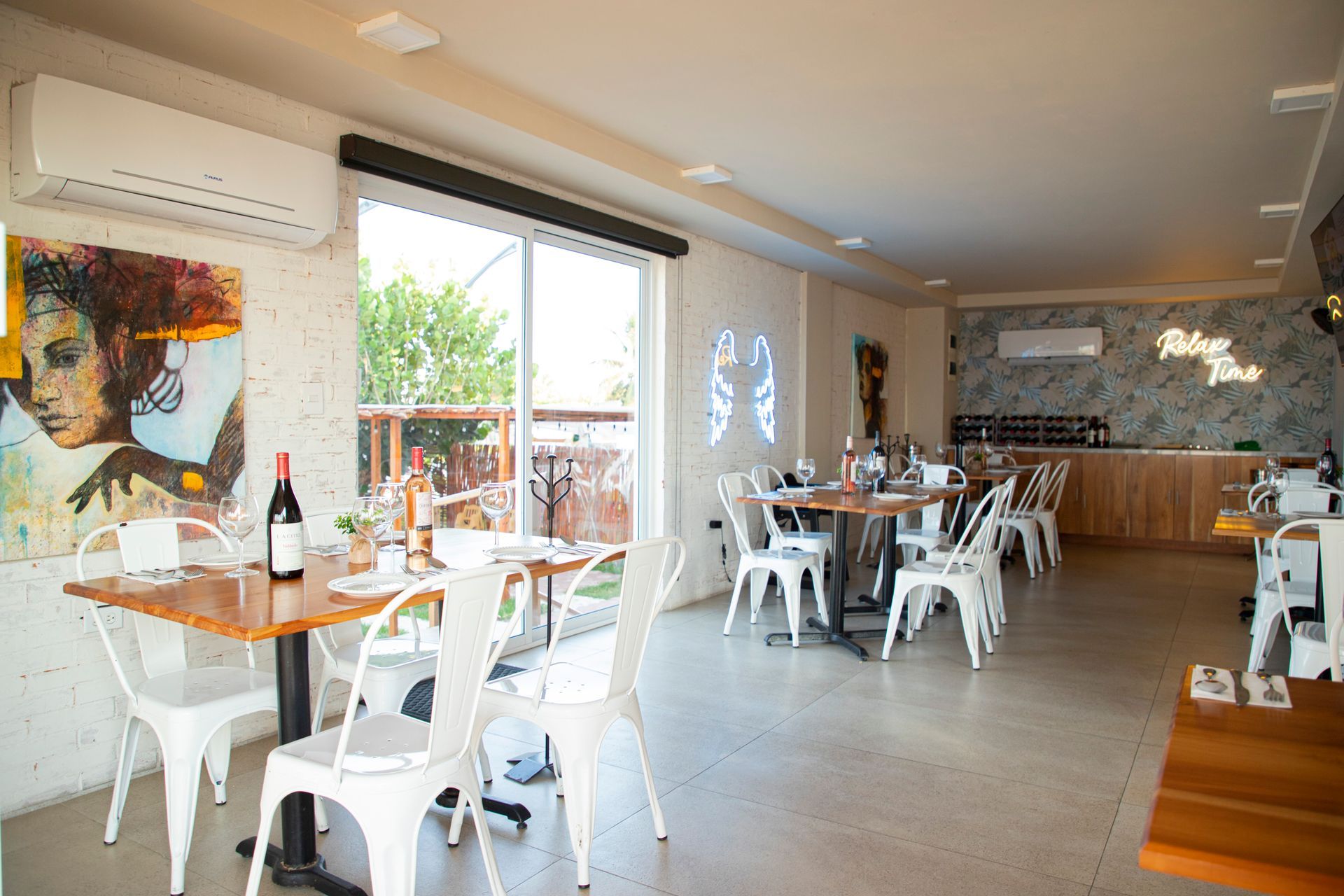 Un restaurante con mesas y sillas y un cuadro en la pared.