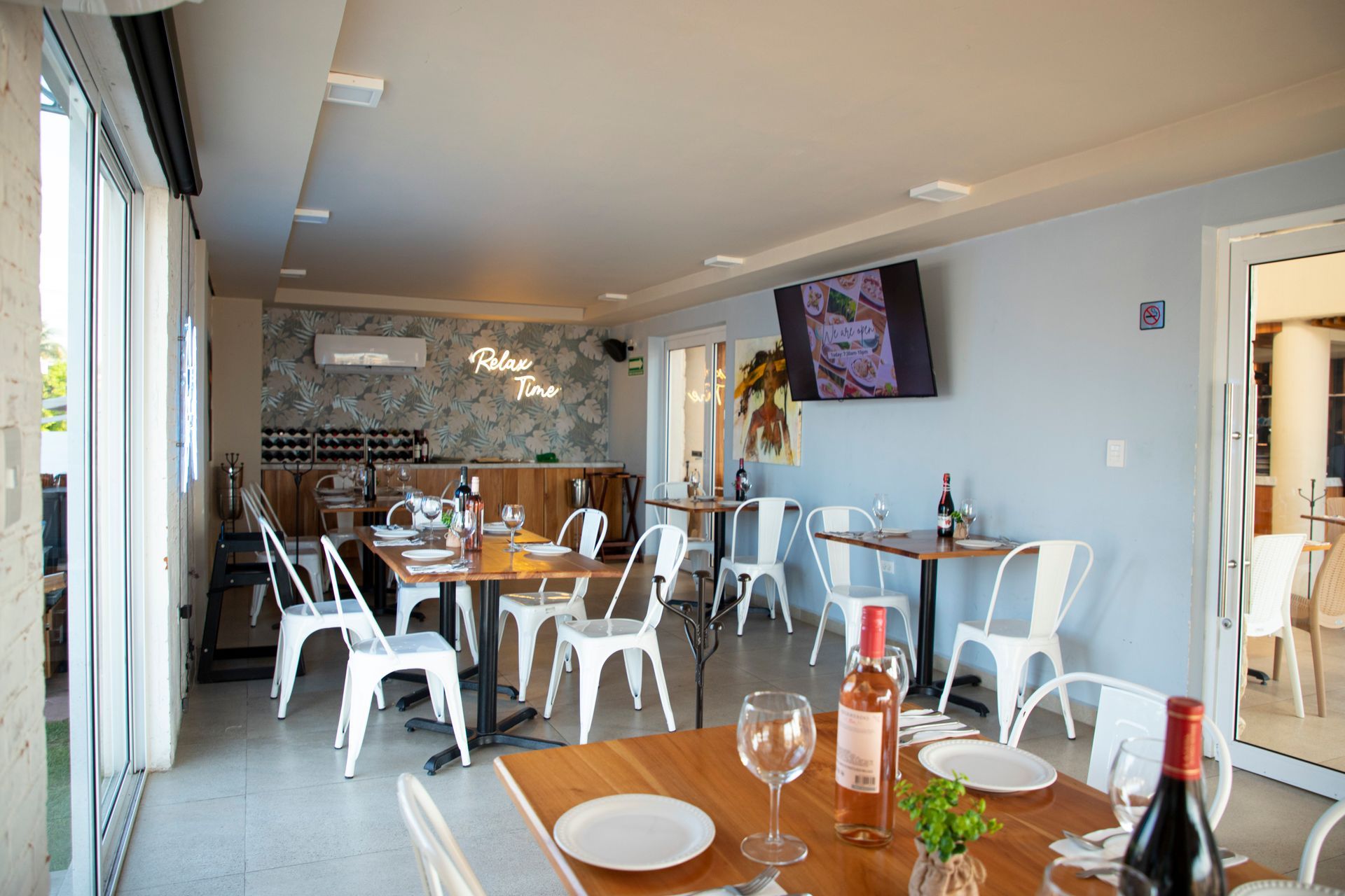 Un restaurante con mesas y sillas y una botella de vino en la mesa.