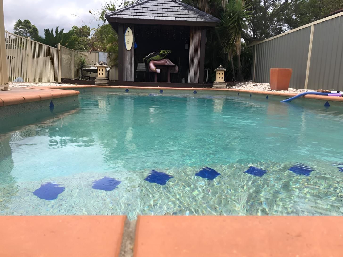 A Large Swimming Pool With A Gazebo In The Background — Aqua Duck Pool Care In Caloundra, QLD