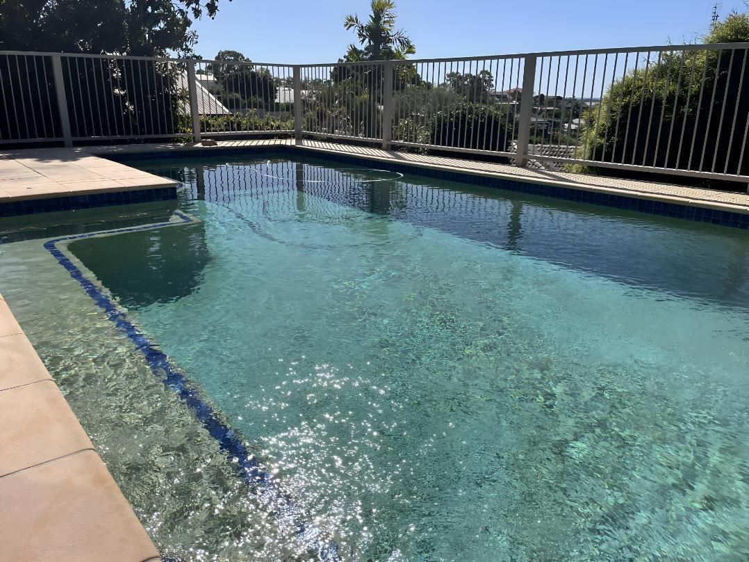 A Large Swimming Pool With A Fence Around It — Aqua Duck Pool Care In Landsborough, QLD