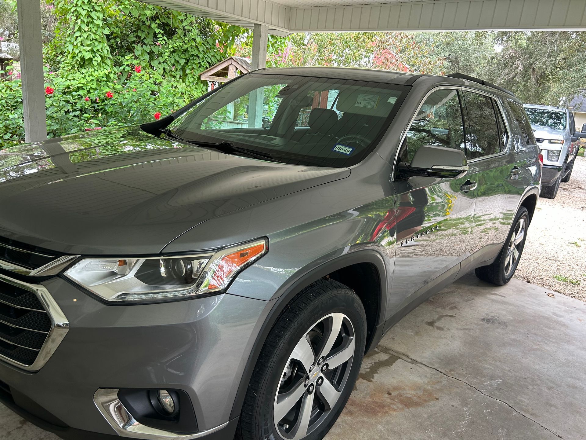 Gray Chevrolet Traverse SUV parked under a carport.