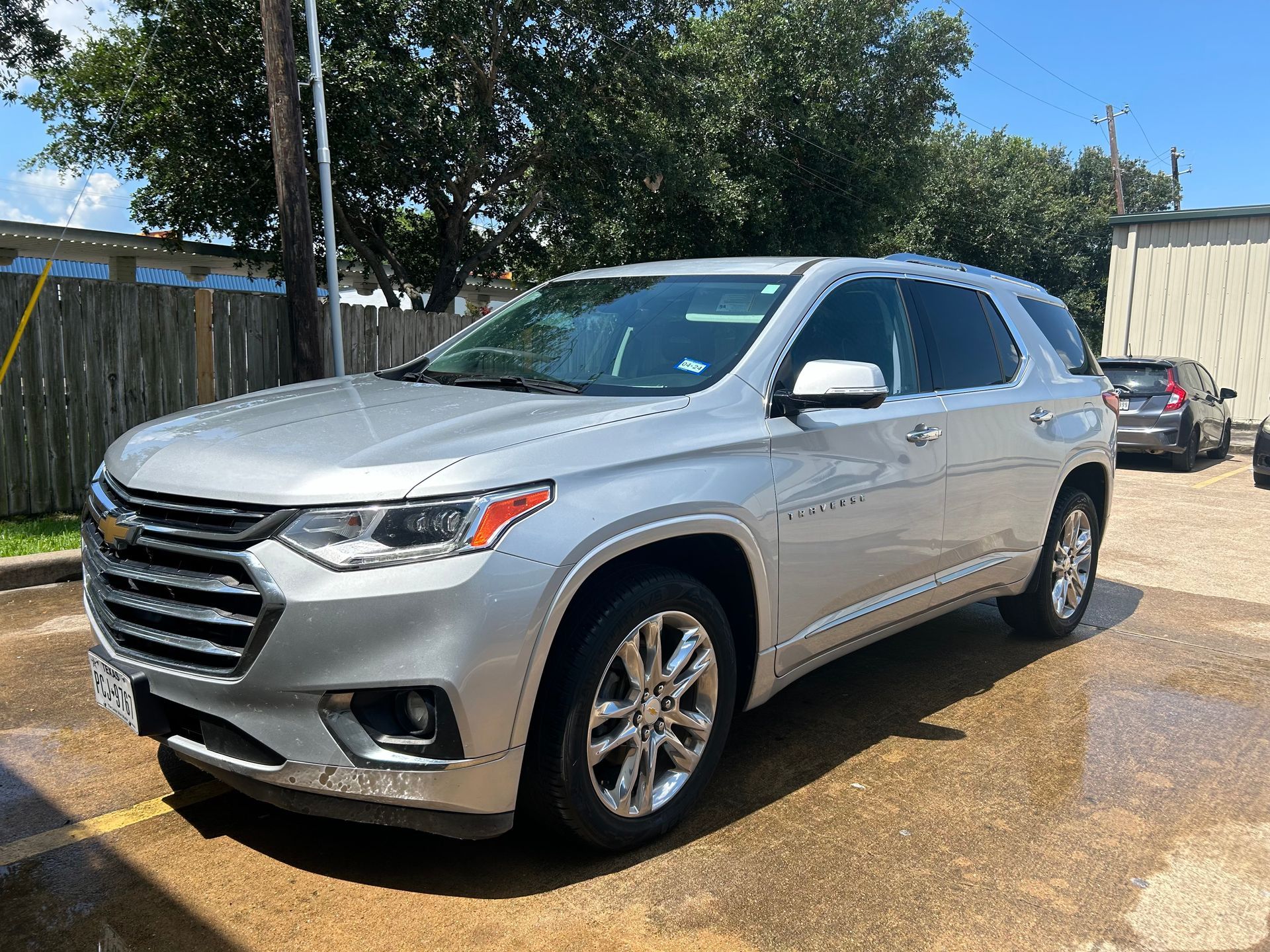 Silver Chevrolet Traverse SUV parked outdoors on a sunny day.