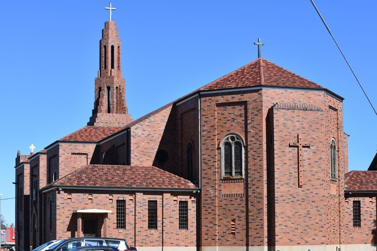 A Large Brick Church With A Cross On Top Of It — Grafton Hire In Casino, NSW