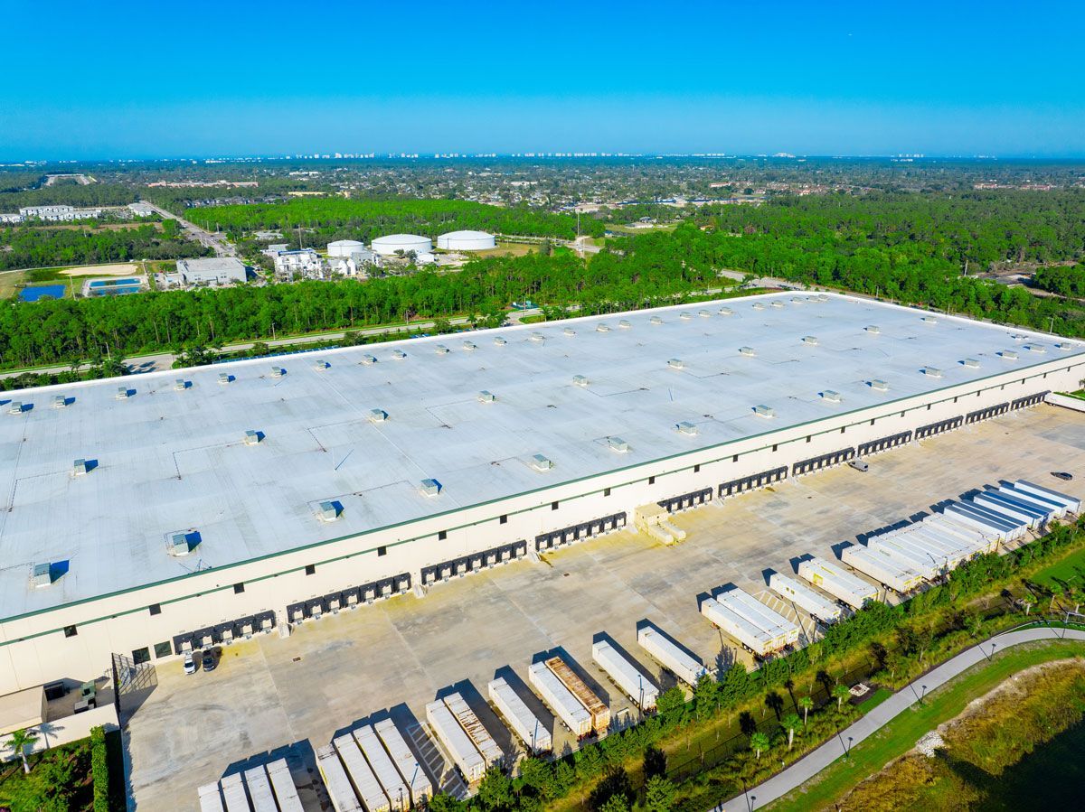 An aerial view of a large warehouse with a lot of trucks parked in front of it.