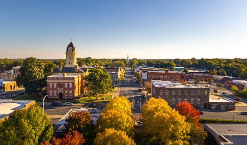 An aerial view of a small town with a clock tower in the background.