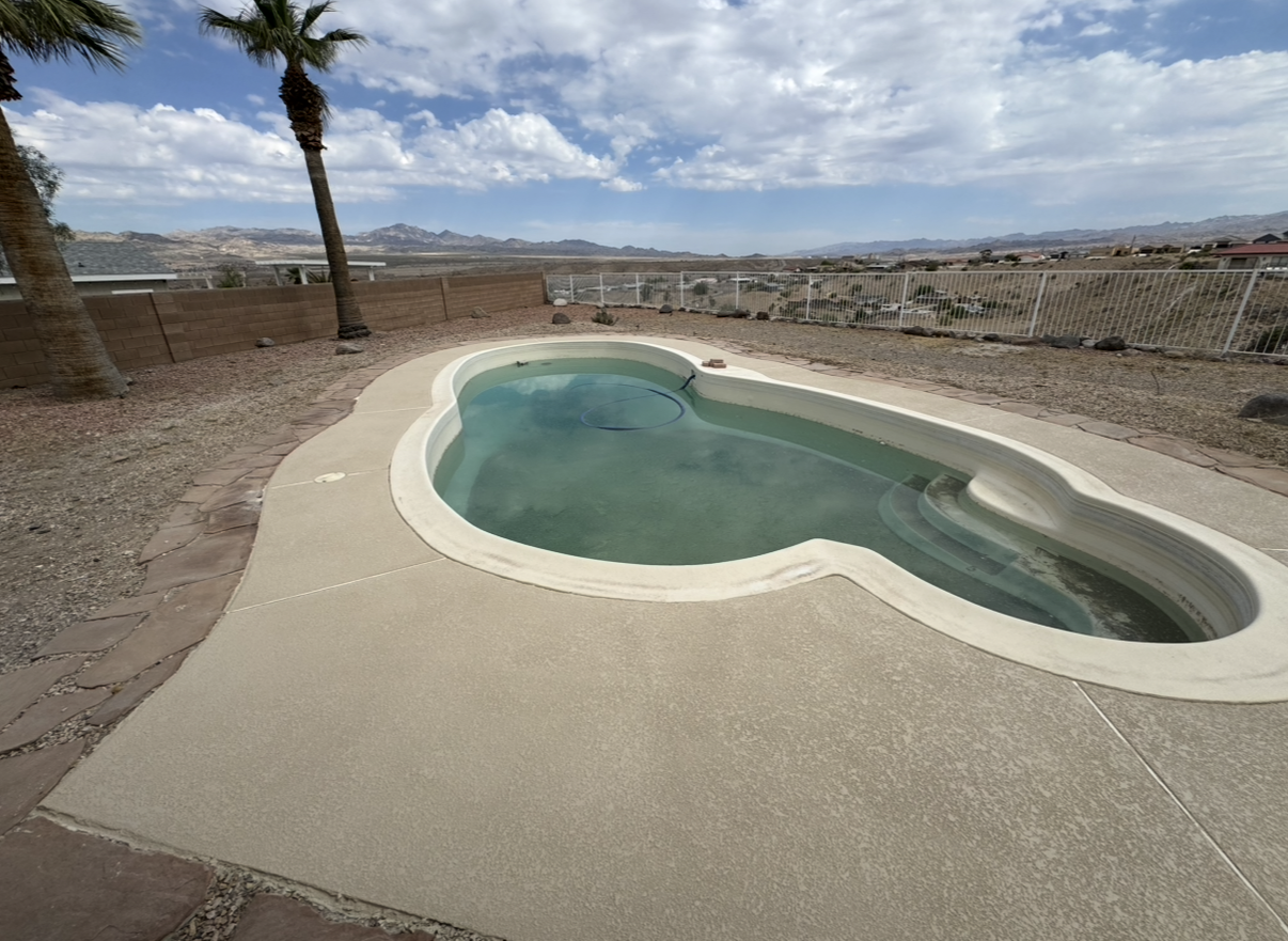 Wooden deck surrounds a turquoise pool with built-in steps.