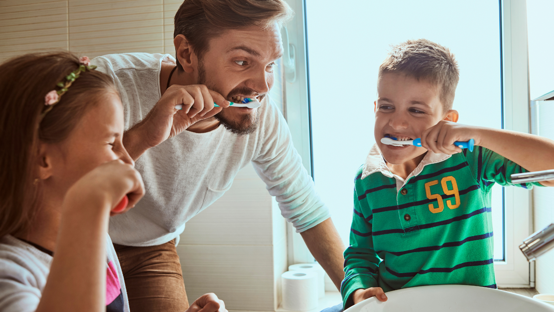 a family having fun while brushing teeth together