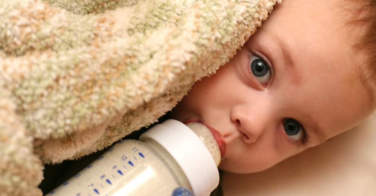 baby holding a milk bottle