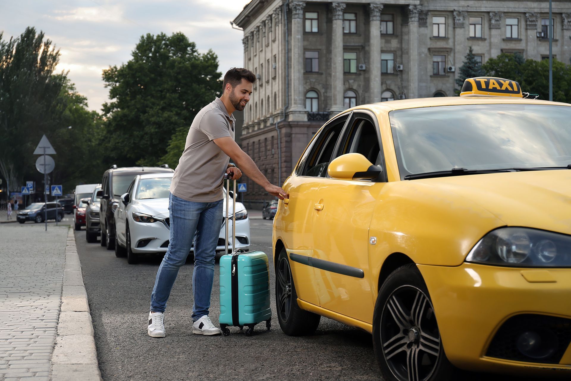 A man is pushing a suitcase into a taxi.