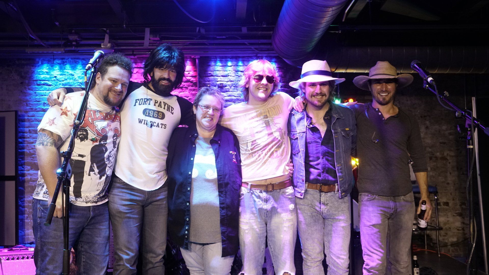 A group of people are posing for a picture on a stage.