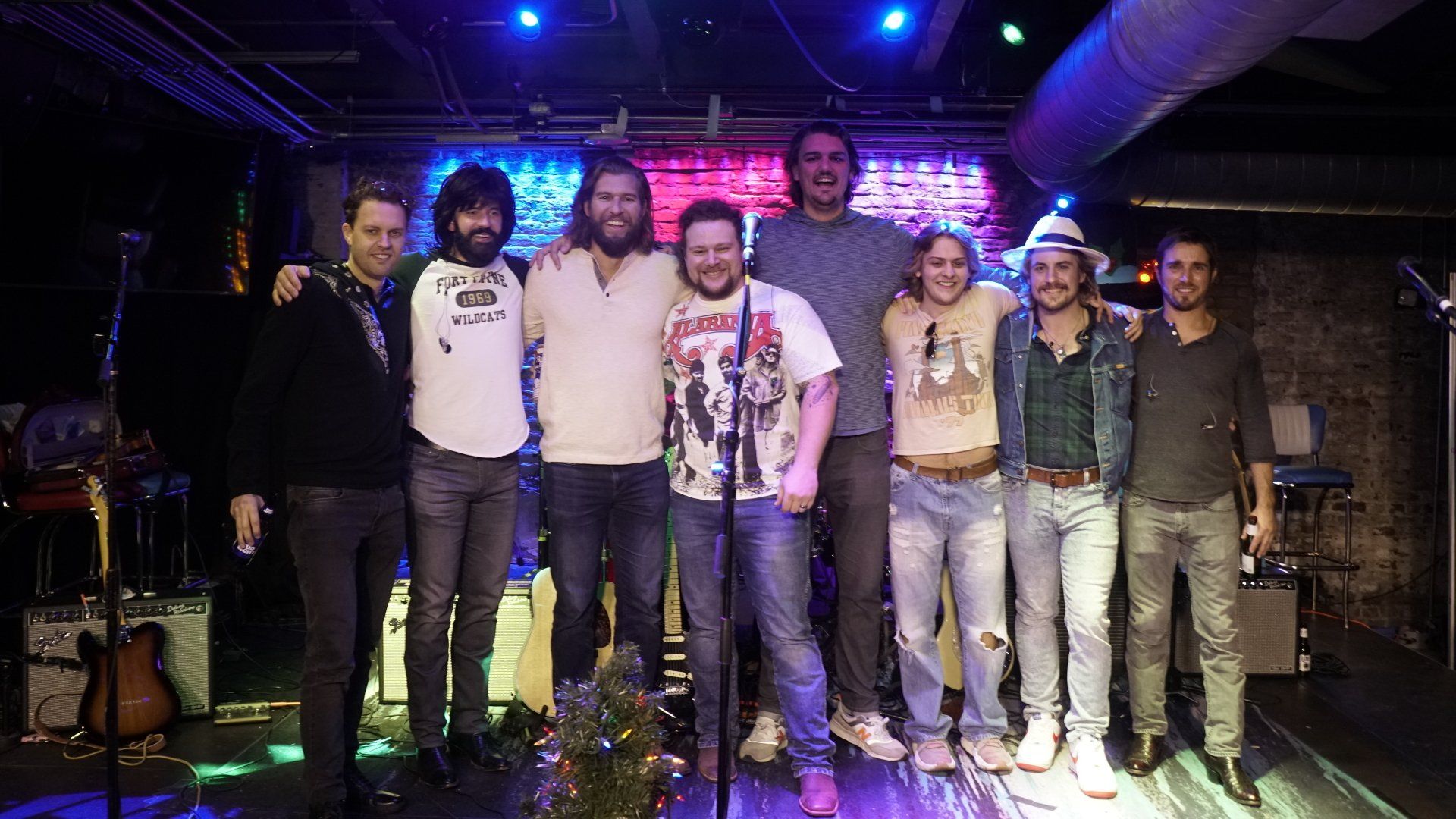 A group of men are posing for a picture in front of a microphone.