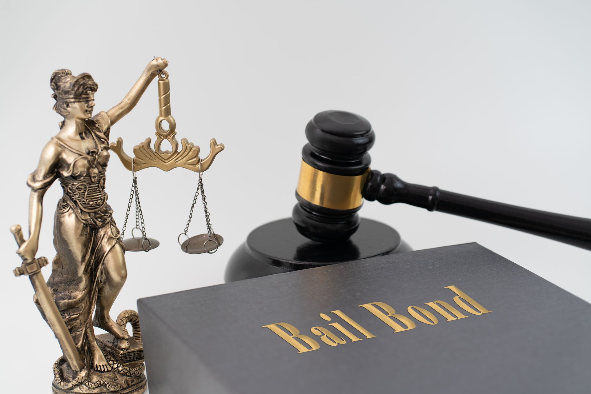 Statue of Lady Justice with scales, a gavel, and a book titled