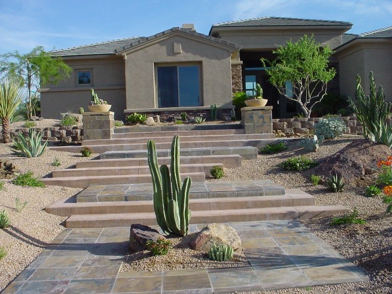 A house with stairs and a cactus in front of it