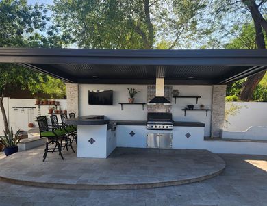 An outdoor kitchen with a stove and a television