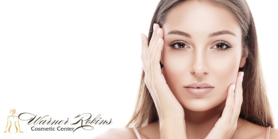 Woman touching her face, promoting Warner Robins Cosmetic Center.