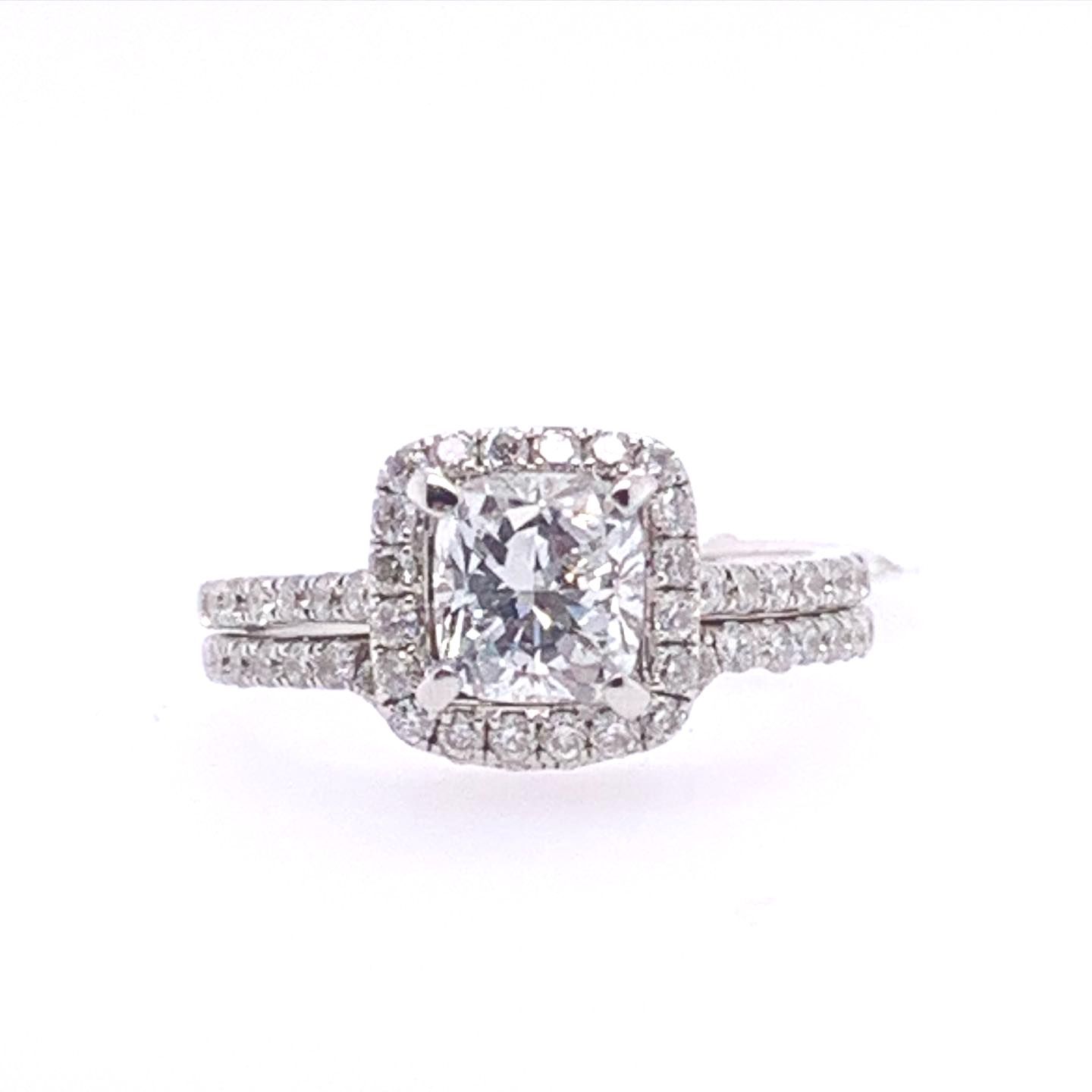A white gold ring with a square diamond in the center surrounded by smaller diamonds.