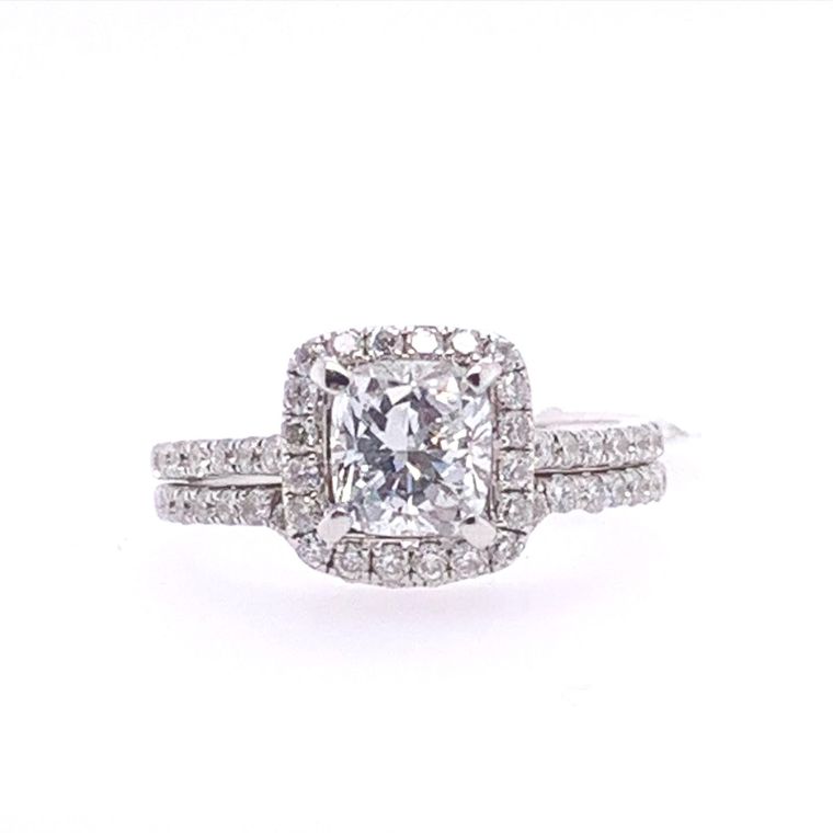 A white gold ring with a square diamond in the center surrounded by smaller diamonds.
