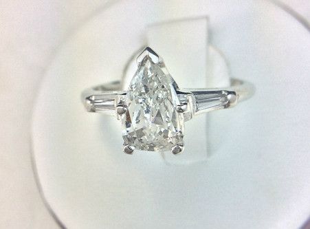 A diamond ring with a pear shaped diamond in the center