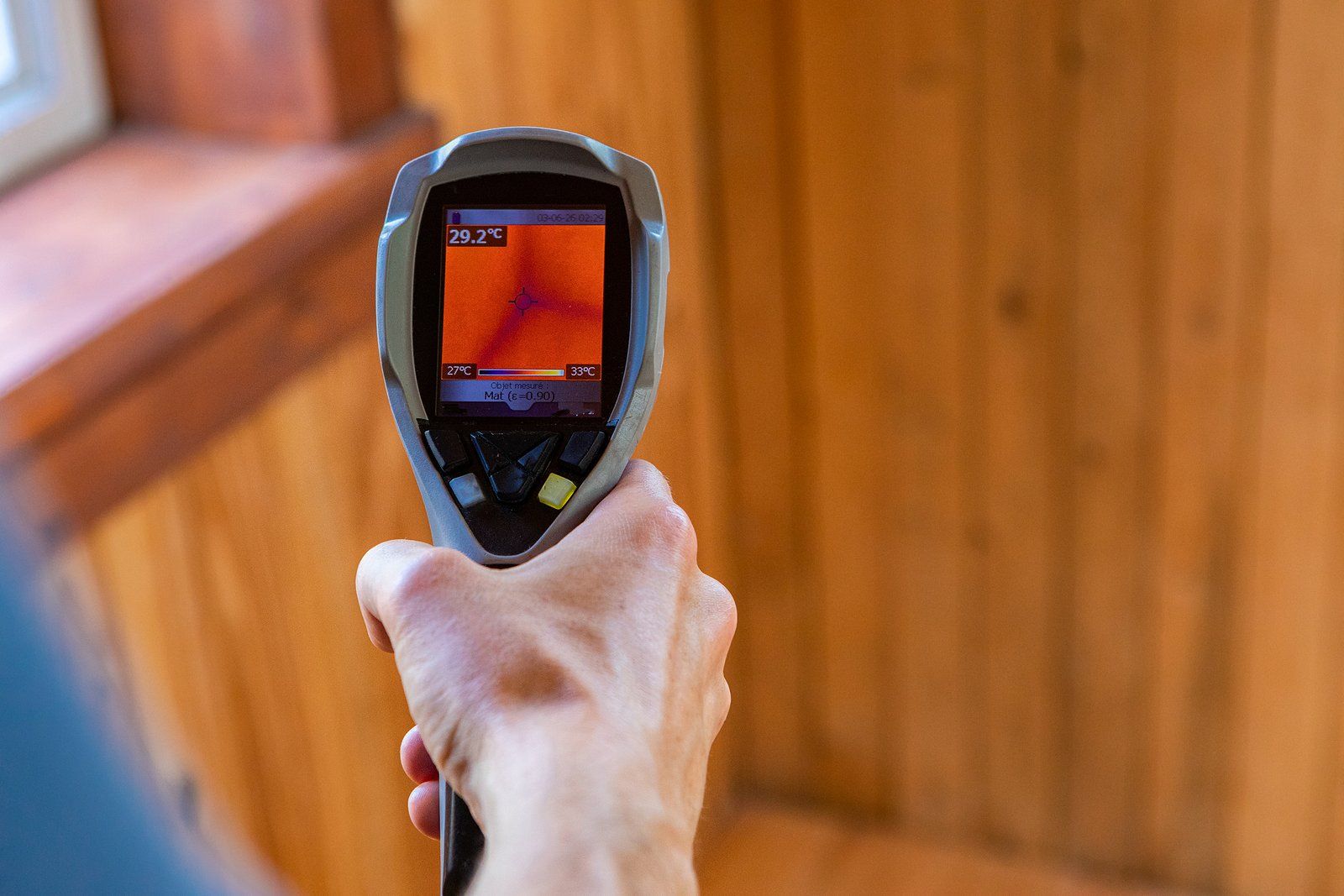A person is holding a thermal camera in their hand.
