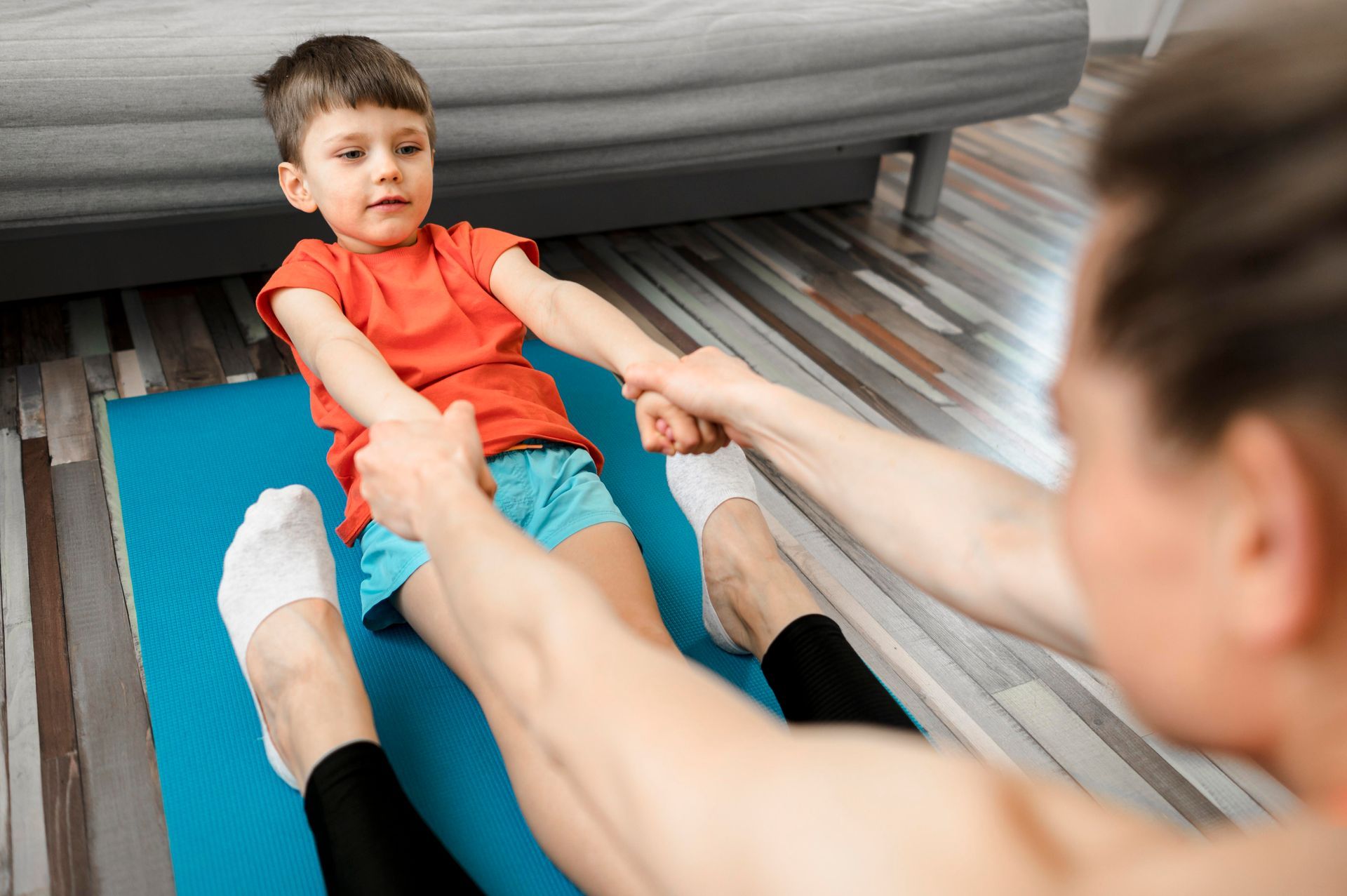 A man and a little boy are doing exercises on a yoga mat.
