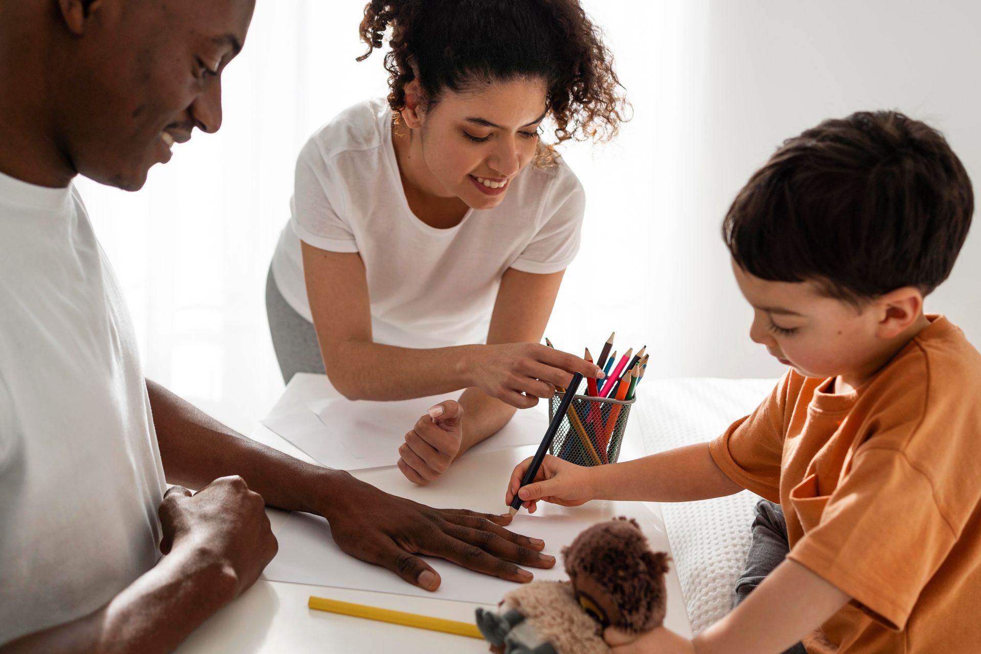 A family is sitting at a table drawing together.