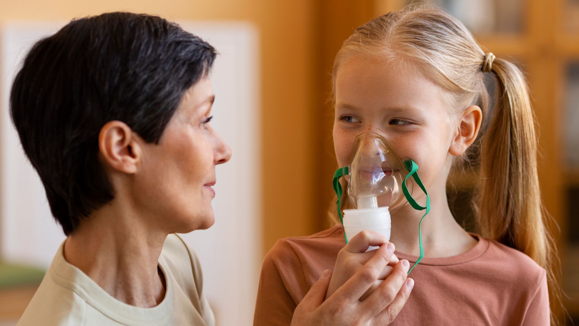 A woman is giving a child an oxygen mask.