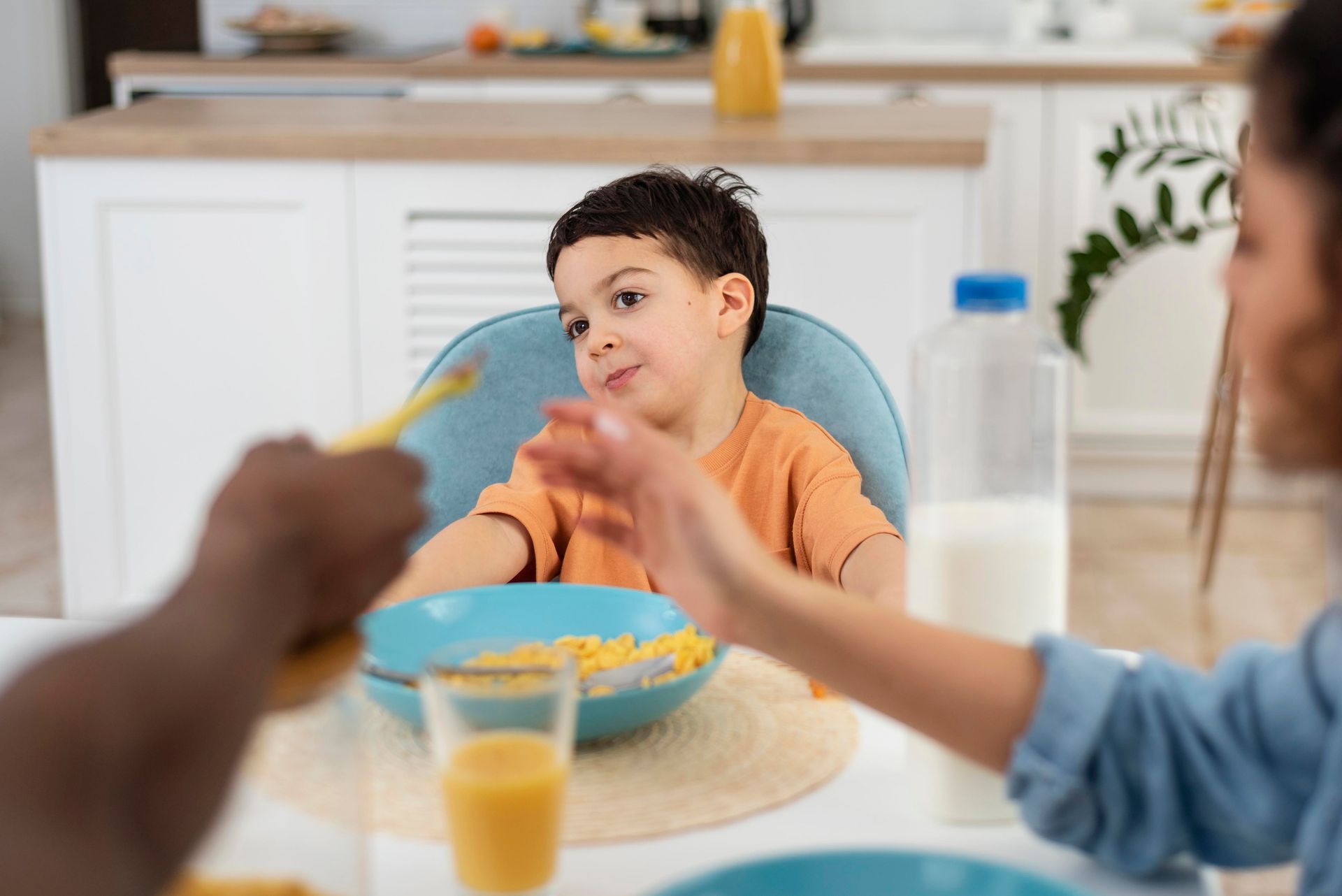 A woman is feeding a child cereal at a table.